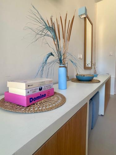a counter with two books and a blue vase at Sea and Sand Elafonisos in Elafonisos