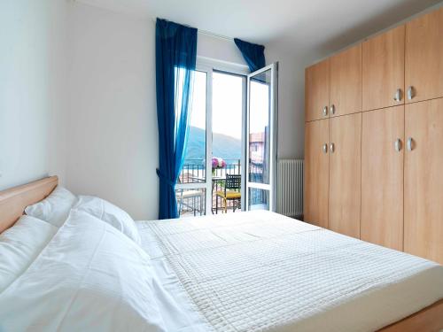 a bedroom with a bed and a view of a balcony at Sunny View Lake Como Apartment- Trilo in Consiglio di Rumo