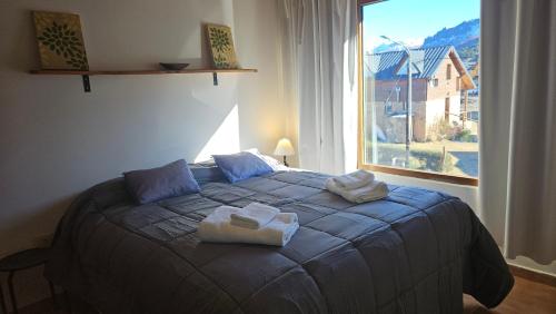 a bedroom with a blue bed with towels on it at KILKA's in Caviahue