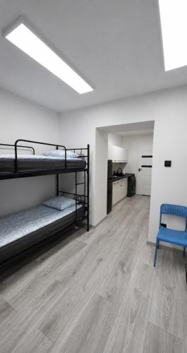 a room with two bunk beds and a blue chair at Przystanek Wałbrzych in Wałbrzych