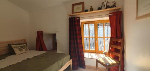 a bedroom with a bed and a window at Duplex de l'abbaye in Pébrac