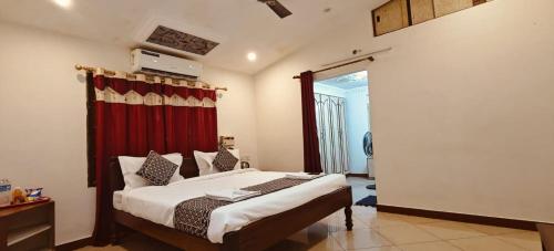 a bedroom with a bed with a red curtain at Sun Private Pool Villa in Puducherry Airpoert