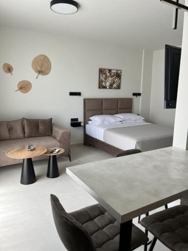 a bedroom with a bed and a couch and a table at House 29 Suites in Heraklio