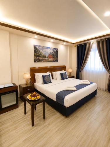 a bedroom with a large bed and a table at Sky Royal Hotel in Petra