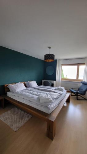 a bedroom with a large bed with a green wall at Appartement Randogne avec grande terrasse in Crans-Montana