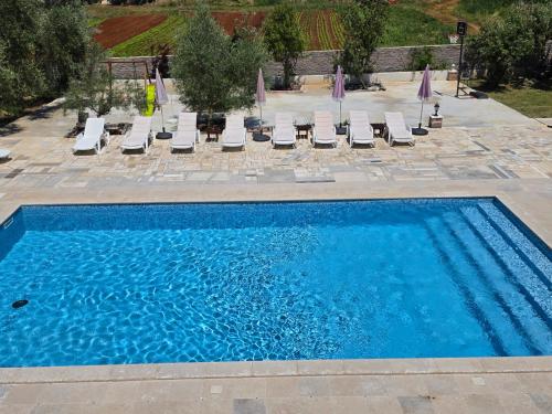 a swimming pool with chaise lounge chairs and a swimming pool at Apartments Šeherzada in Pula