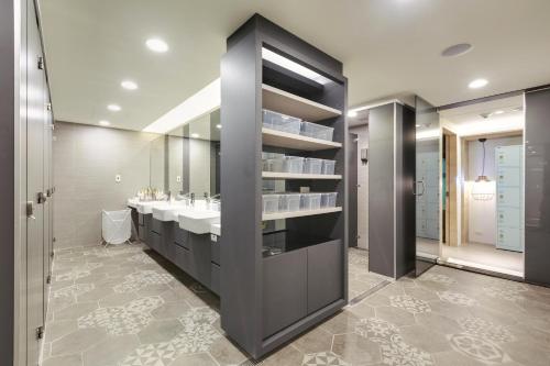 Taiwan Youth Hostel & Capsule Hotel في تايبيه: حمام به مغسلتين ومرآة كبيرة