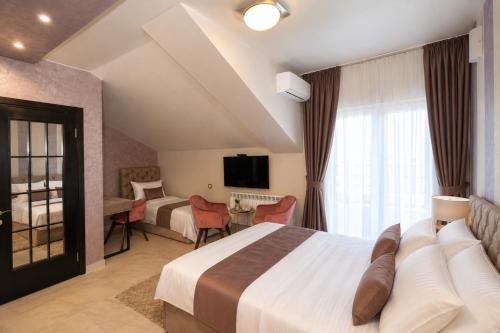 a hotel room with a bed and a tv at Hotel Bajadera Lux in Belgrade