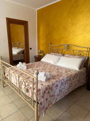 a bedroom with a bed with a yellow wall at Villa G&G in Tropea