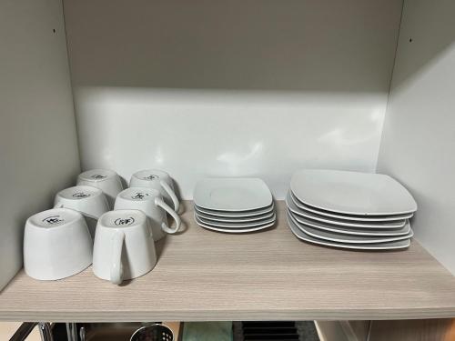 a shelf with plates and cups and dishes on it at Lagos centro Temuco in Temuco
