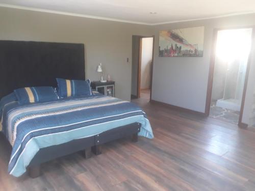 a bedroom with a large bed with blue sheets at la casa del cerro in Olmué