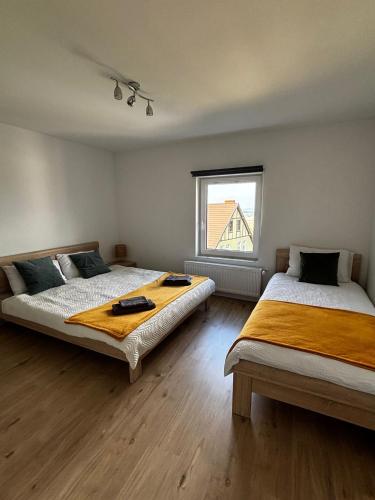 two beds in a large room with a window at Apartament Eden in Srebrna Góra