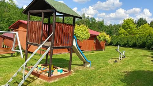 a playground with a slide and a play structure at Noclegi U Renaty Solina in Solina