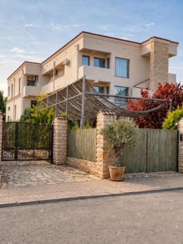 a house with a wooden fence and a fence at Artelier Vama Veche in Vama Veche
