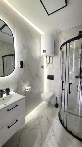 a white bathroom with a sink and a shower at Przystanek Wałbrzych in Wałbrzych
