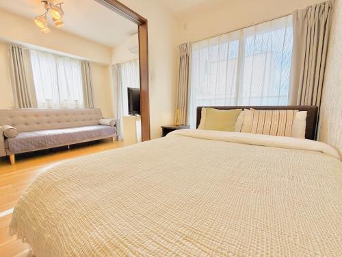 a bedroom with a large bed and a couch at u-heim Osaka Tengachaya in Osaka