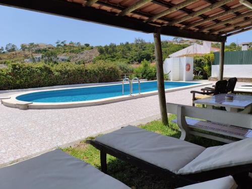 a view of a swimming pool with a table and chairs at Porto Monte in Maceira