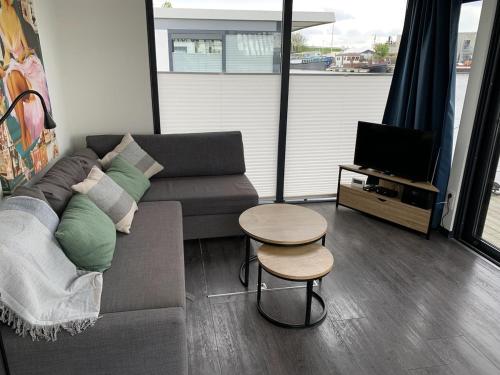 a living room with a couch and a table and a tv at EVASION in Nieuwpoort