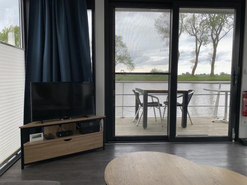 a living room with a flat screen tv and a table at EVASION in Nieuwpoort