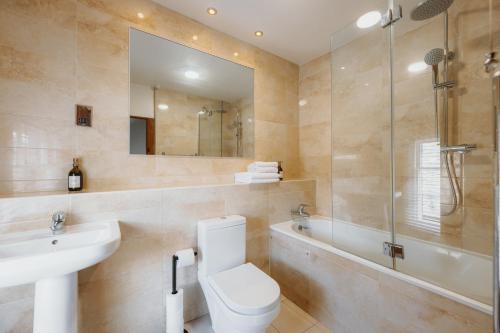 a bathroom with a toilet and a sink and a tub at Wenlock's Cosy Cottage in Much Wenlock