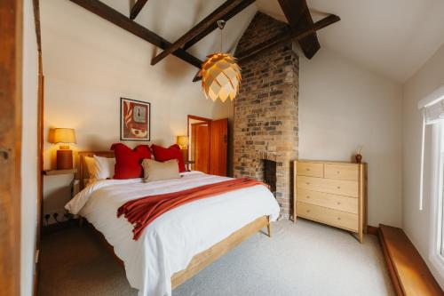 a bedroom with a large bed and a brick wall at Wenlock's Cosy Cottage in Much Wenlock
