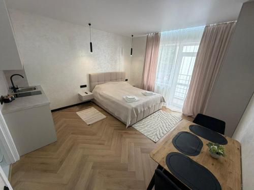 a small room with a bed and a table at Поляна Апарт in Polyana