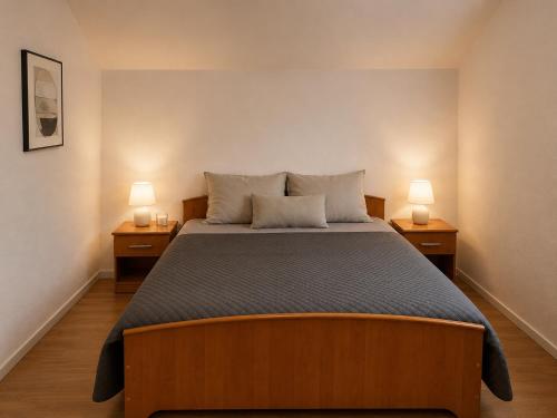 a bedroom with a large bed with two lamps on both sides at Villa Zlatan Poolside in Bosanska Gradiška