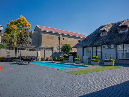 a house with a swimming pool in front of a building at 5@Partridge Guesthouse in Newcastle