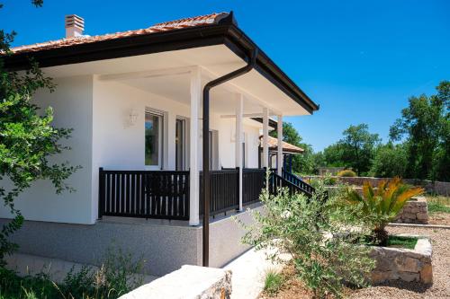 a small white house with a balcony at Barcelona Hacienda in Gostovići