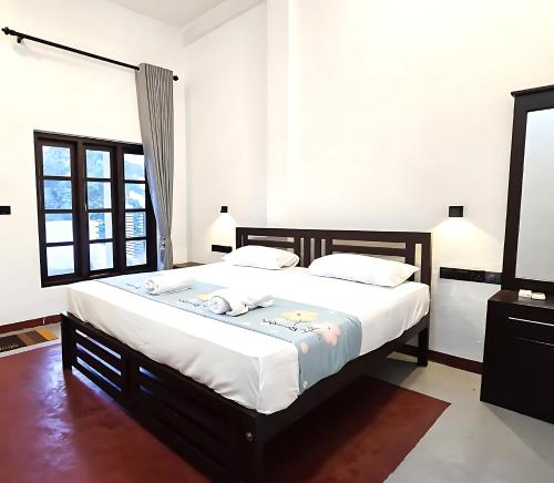 a bedroom with a large bed with white sheets at Surf and stay A- Bay in Arugam Bay