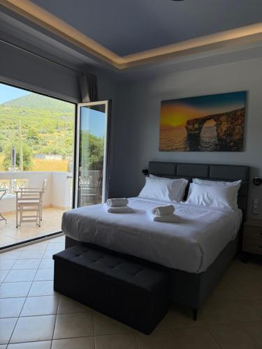 a bedroom with a large bed and a balcony at VILLA Konstantinos in Agios Georgios