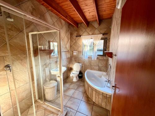 a bathroom with a tub and a toilet and a shower at Nghala Self-catering Holiday Home in Marloth Park