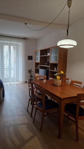 a dining room with a wooden table and chairs at Casa Pino Malè in Malè