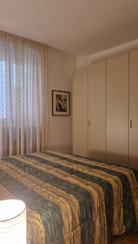 a bedroom with a large bed and a window at Casa Pino Malè in Malè