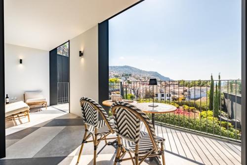 a room with a balcony with a table and chairs at Luxury 5-Star Stay at Savoy Insular in Funchal