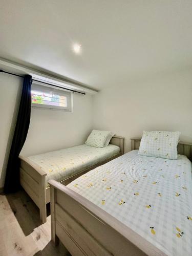 a bedroom with two beds and a window at Beau T3 à 15 min de Lyon in Pierre-Bénite