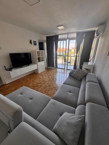 a living room with a couch and a flat screen tv at Apartment 7 in Izola