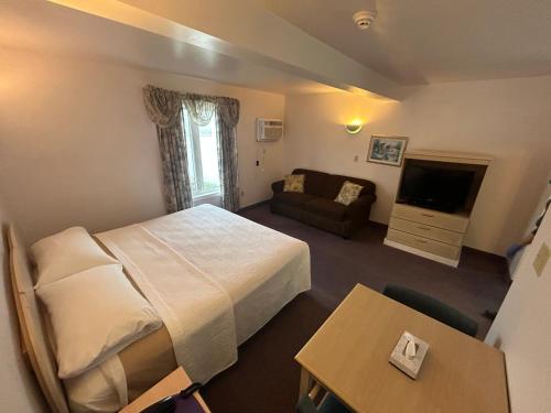 a hotel room with a bed and a television at Centennial Motel in Sauble Beach