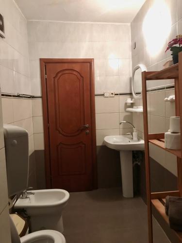 a bathroom with a toilet and a sink and a door at Mollys apartment 1 in Pogradec