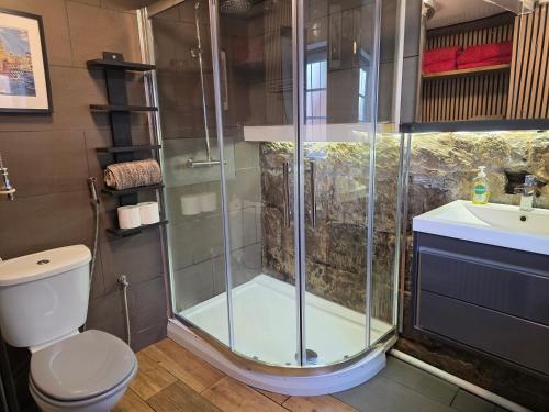 a bathroom with a shower and a toilet and a sink at Sea-Quinn Views in Wallasey