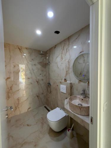 ein Badezimmer mit Toilette und Waschbecken in der Unterkunft Azure Haven in Dhërmi