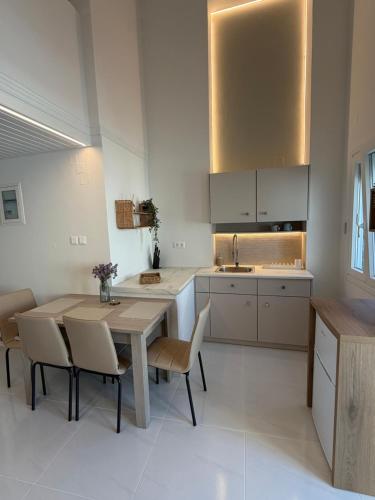 a kitchen with a wooden table and chairs at Afroditi Syros in Ermoupoli