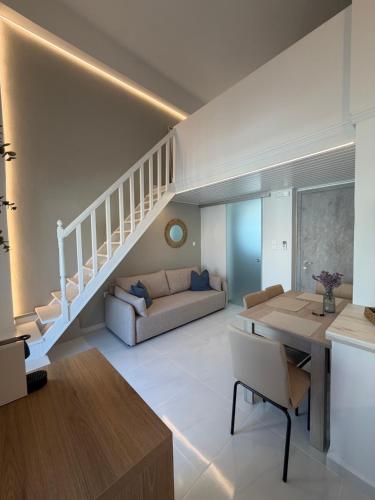a living room with a staircase and a couch at Afroditi Syros in Ermoupoli