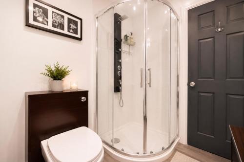 a bathroom with a glass shower with a toilet at 4 Bedroom Cardiff Bay View House in Cardiff
