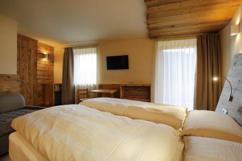 Ένα ή περισσότερα κρεβάτια σε δωμάτιο στο Albergo Garnì Antico Mas del Medico
