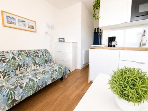 a living room with a couch and a kitchen at Studio - Marina 4 - 17 allée des Pinons - 5-1 in Saint-Jean-de-Monts