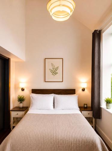 a bedroom with a bed with two tables and a chandelier at 4 Bedroom Cardiff Bay View House in Cardiff