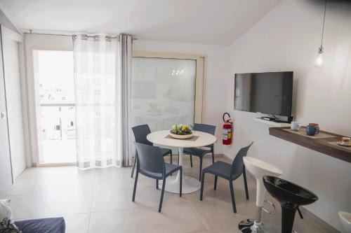 a dining room with a table and chairs and a tv at Dai Massari in Villaggio Azzurro