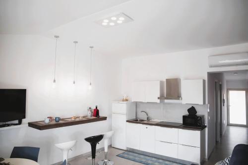 a white kitchen with a sink and a counter at Dai Massari in Villaggio Azzurro