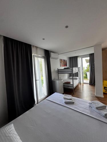 ein Schlafzimmer mit einem großen weißen Bett und Fenstern in der Unterkunft Azure Haven in Dhërmi
